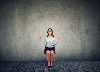 Meditating woman on chair with eyes closed