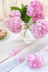 Bouquet of pink flowers in a glass vase on a light background