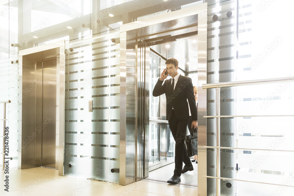 Wall mural successful and young businessman in the elevator business center rides to work