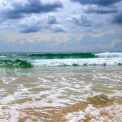 Sandy beach. Dramatic cloudscape with heavy rain and tropical storm at the horizon on the coastline of Sri Lanka.