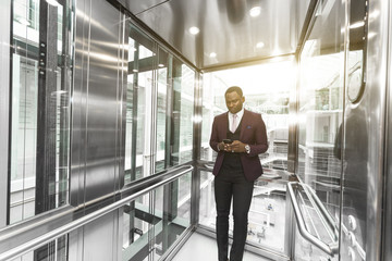 successful and young businessman in the elevator business center rides to work