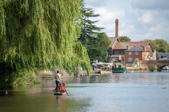 stratford upon Avon Warwickshire England UK August 23rd punt under a willow tree with beautiful buildings and bridge in the background during English summer