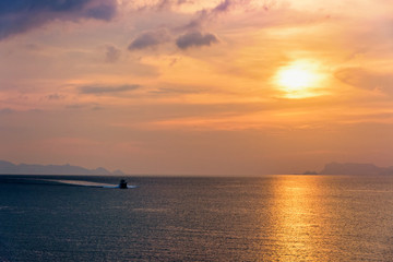 Fototapeta premium Speedboat for fishing on the sea returning to shore during the sunset in the midst of nature and the beautiful sky.
