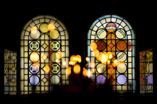 Stained glass windows in church and candles