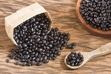 Raw black beans on the wooden background - Phaseolus vulgaris' Black turtle