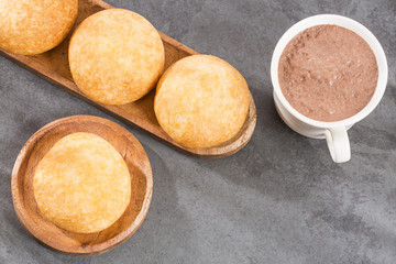 Fototapeta premium Almojabana, traditional Colombian food - Drink of chocolate. Top view