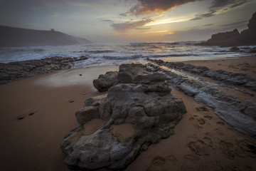 Fototapeta na wymiar Seascape, Sunset in Tagle beach. panoramic view of nice colorful huge cliff and sea on the back. Cantabria. Spain.