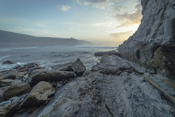 Fototapeta premium Sunset in Tagle beach. panoramic view of nice colorful huge cliff and sea on the back. Cantabria. Spain.