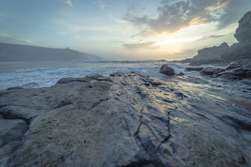 Sunset in Tagle beach. panoramic view of nice colorful huge cliff and sea on the back. Cantabria. Spain.