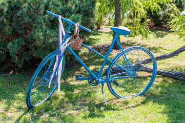 Fototapeta premium Old blue bicycle in the garden