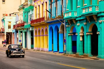 Photo sur Plexiglas Caraïbes Scène de rue avec une vieille voiture classique et des bâtiments colorés à La Havane
