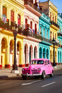 Classic car and colorful buildings at sunset in Old Havana