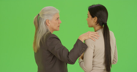 White female boss talks to employee on green screen