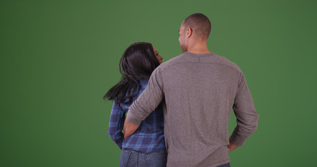 Embracing African American couple looking out to the distance on green screen - Powered by Adobe