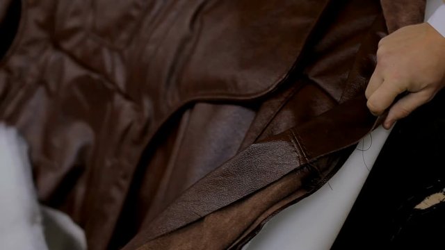 Master chops the sofa with leather. Production process at the furniture factory. Manufacture of upholstered furniture