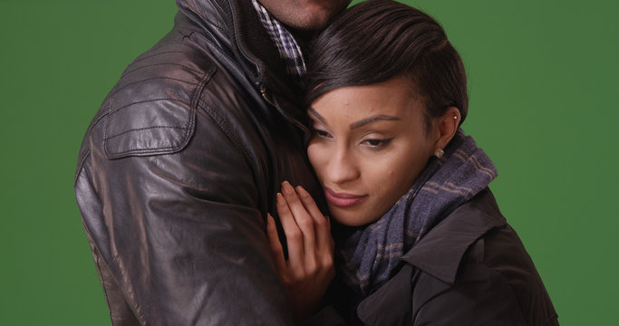 African-American woman hugging boyfriend tenderly on green screen