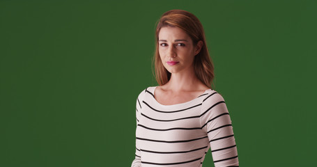 Attractive white woman standing looking at camera on green screen