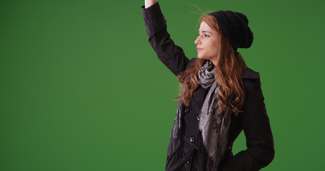 Attractive woman waving for a taxi cab to pick her up on green screen