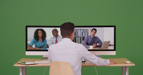 Associates having internet based web conference over video chat on green screen