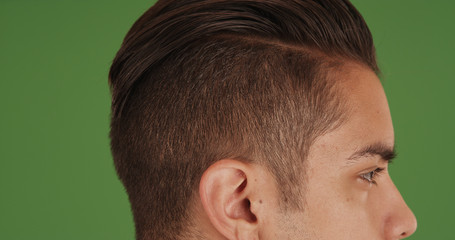 Side view of young millennial man with undercut standing on green screen