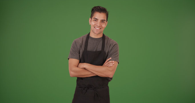 Happy handsome young Latino restaurant employee on green screen