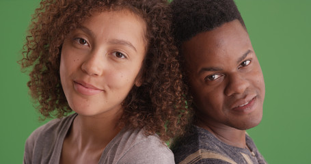 Happy smiling African American man and woman lean on each other on green screen