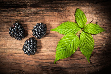 Ripe blackberries leaves on vintage wooden board