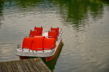 lonely pedal boat at wooden pier