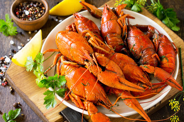 Boiled crawfish, lemon and parsley on a wooden table. Appetizer protein, the concept of healthy eating.