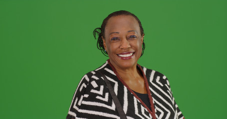 Happy older black woman poses for a portrait on green screen