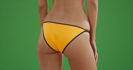 Close up of young millennial bikini girl's butt on greenscreen background