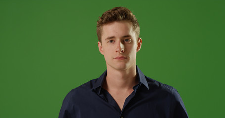 Handsome young Caucasian man looking at camera on green screen