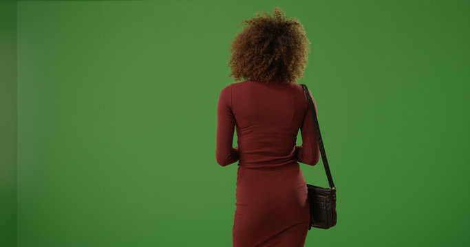 Young Black Woman In Dress Standing With Back To Camera On Green Screen