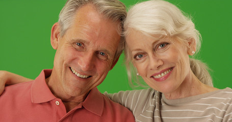 Closeup of happy senior couple smiling at camera on green screen