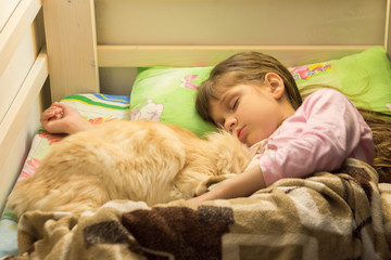 Little girl sleeping in bed with fluffy cat