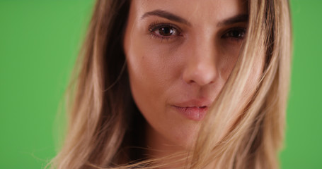 Fototapeta premium Closeup of attractive millennial girl staring at camera on green screen