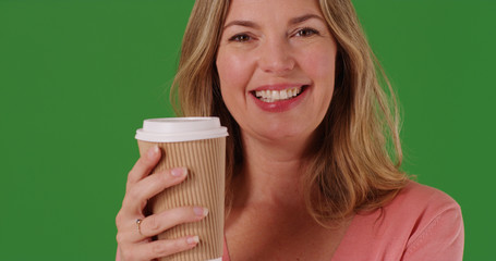 Close up of white woman with coffee smiling at camera on green screen