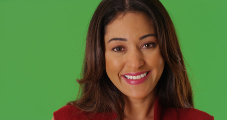 Close up of cheerful Latina female smiling at camera on green screen