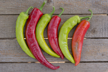 Red and green bitter, hot pepper, on a wooden background, copy space, flatly,
