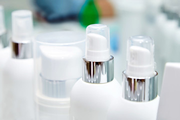 Row of white blank bottles with  cosmetic products. Moisturizing creams and other means for skin care of face and body