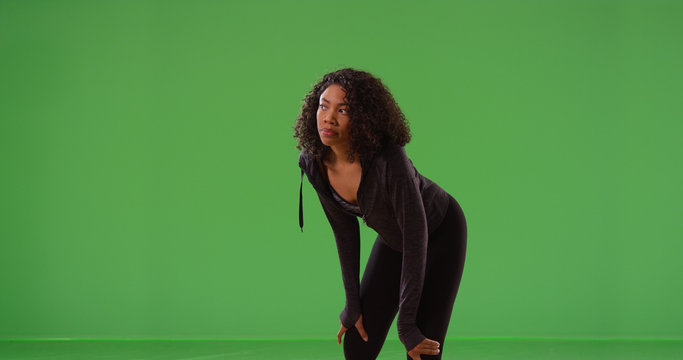 Young black woman runner taking break during workout on green screen - Powered by Adobe