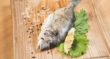 Grilled fish with vegetables on the table