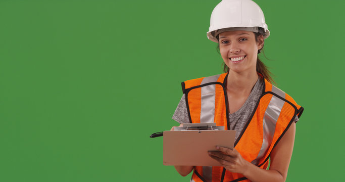 Female construction worker posing with clipboard on green screen