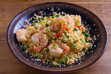 Shrimps with couscous, green peas, leeks and carrot