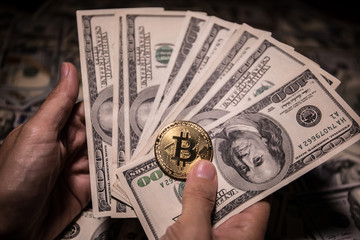 golden bitcoin coin on us dollars close up