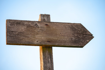 Emtpy wooden singpost with light blue sky background