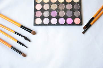 Cosmetic set of brushes and eye shadow on white background