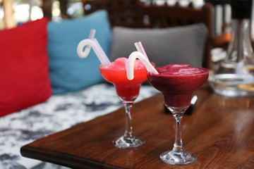 Glasses with delicious cocktails on table indoors