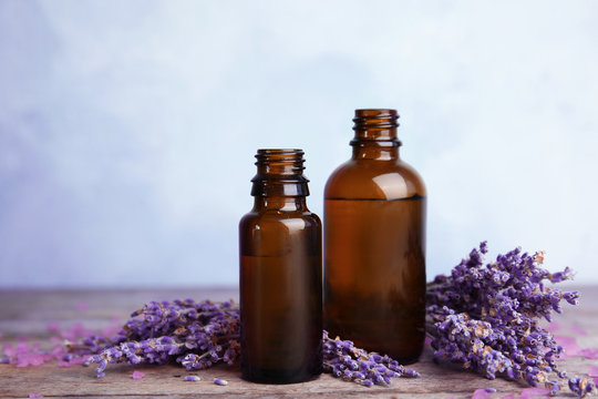 Bottles with aromatic lavender oil on wooden table