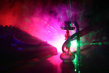 Shisha party club concept. Dj mixer with on dark nightclub background with stylish oriental shisha.